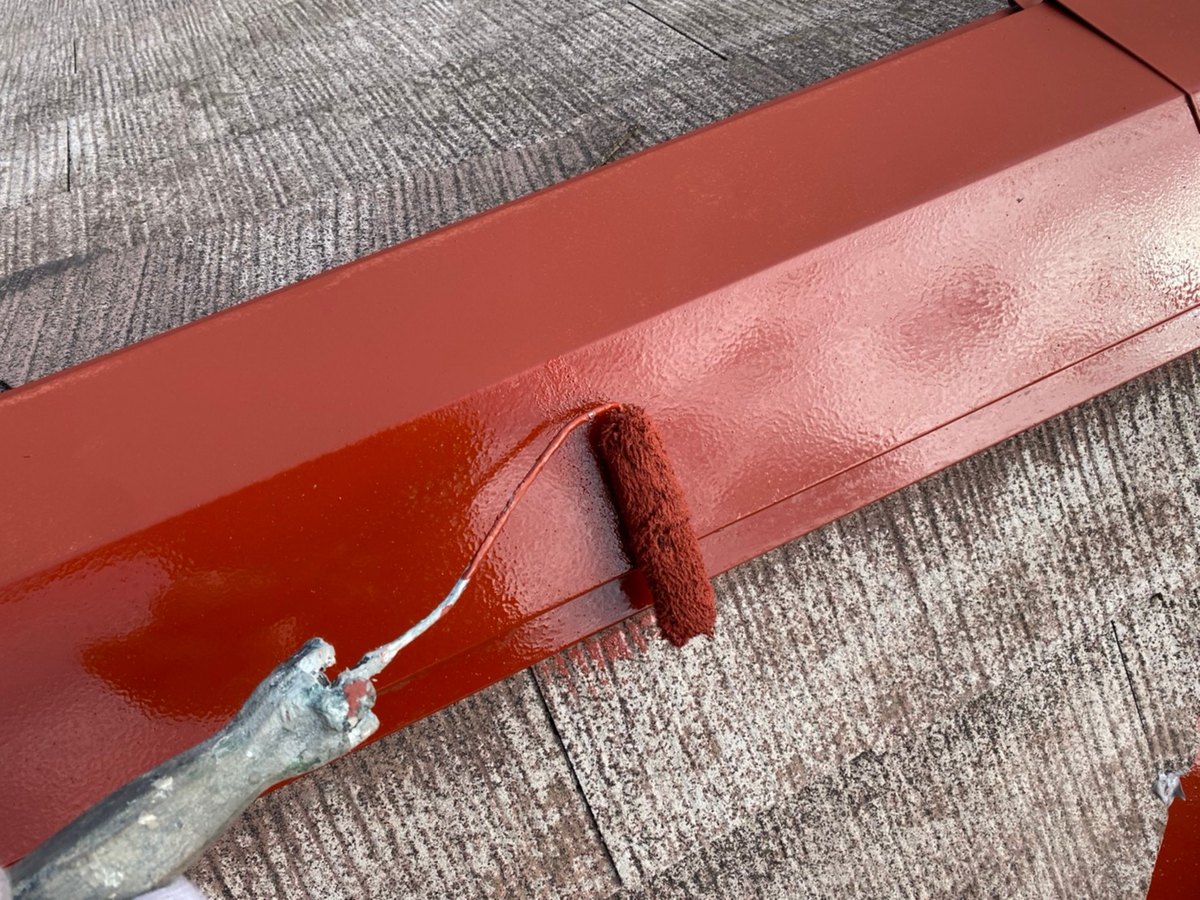 屋根の頂上の棟板金に、錆止めの下塗りをしているところ