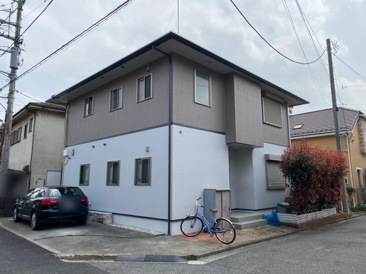施工後の外観（道路の角から）。1階 N-80（白に近い淡い色）、2階 15-50B（灰色がかった茶色）