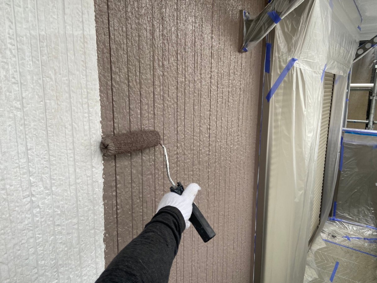 白い下塗りの上に、2階の外壁の中塗り（15-50B）を塗っているところ