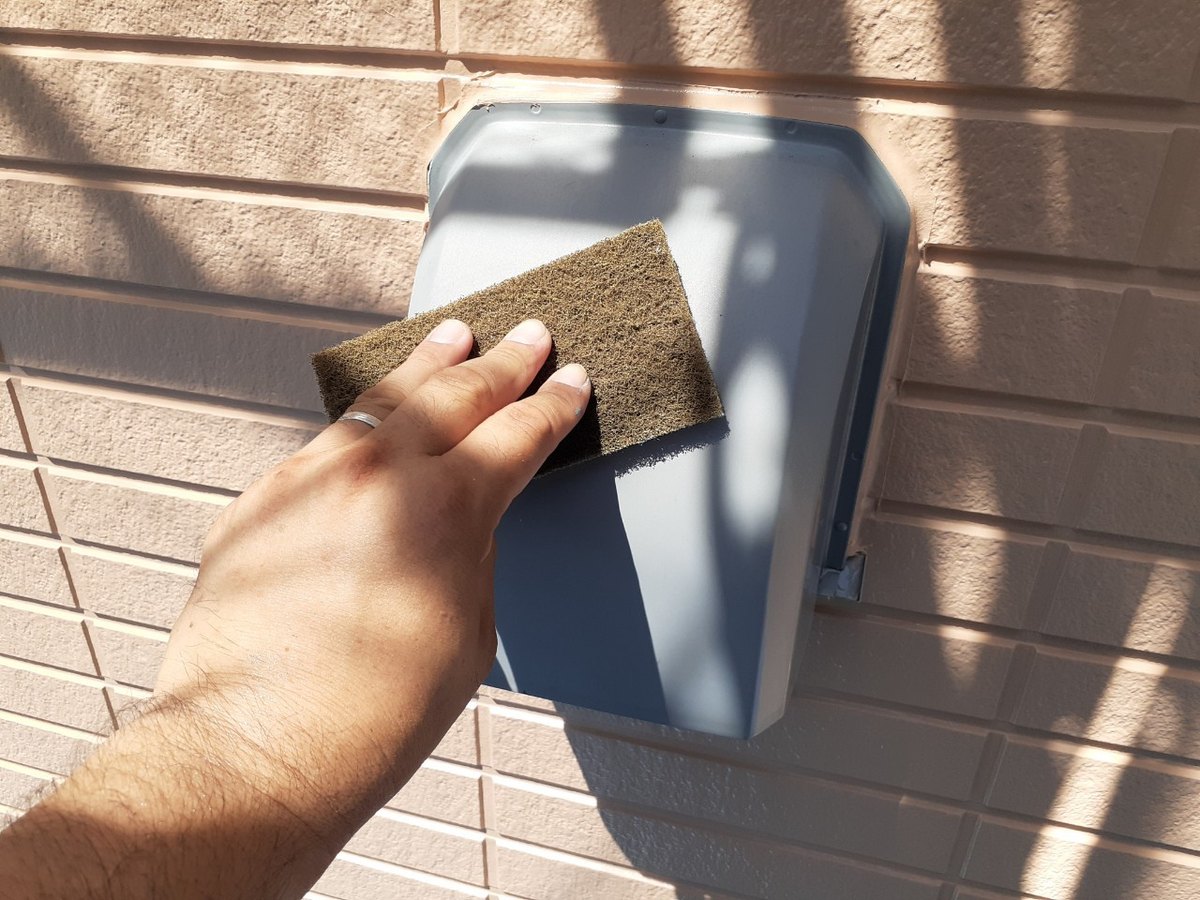 通気口カバーの表面を研磨パッドで荒らしているところ