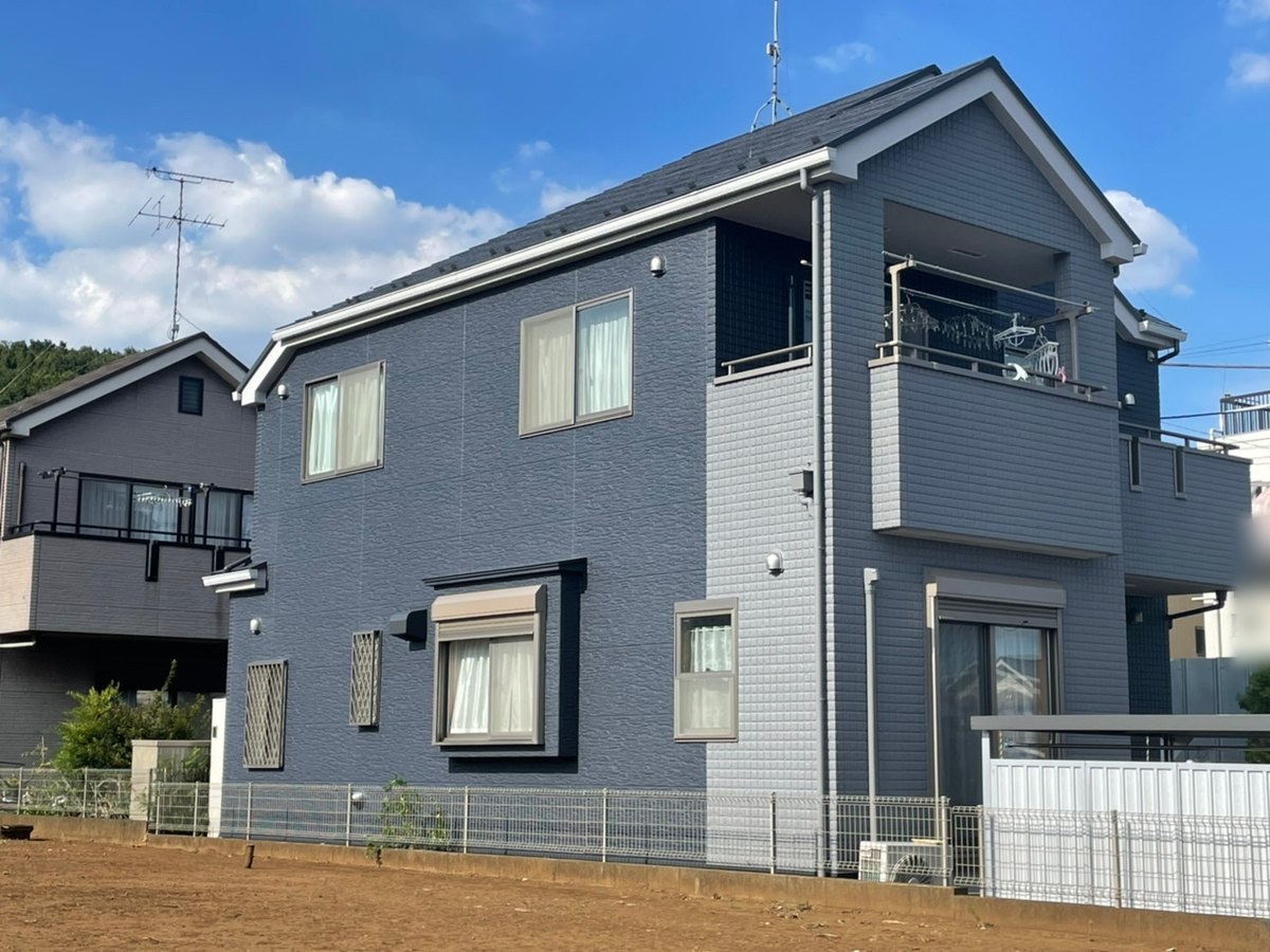 施工後の裏側（地上から撮影）。ネイビー系の外壁とグレー系のスレート屋根