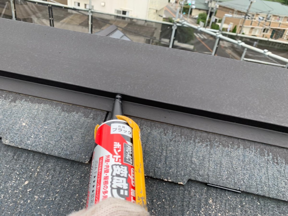 屋根の板金の釘に、抜け止めのコーキングをしているところ