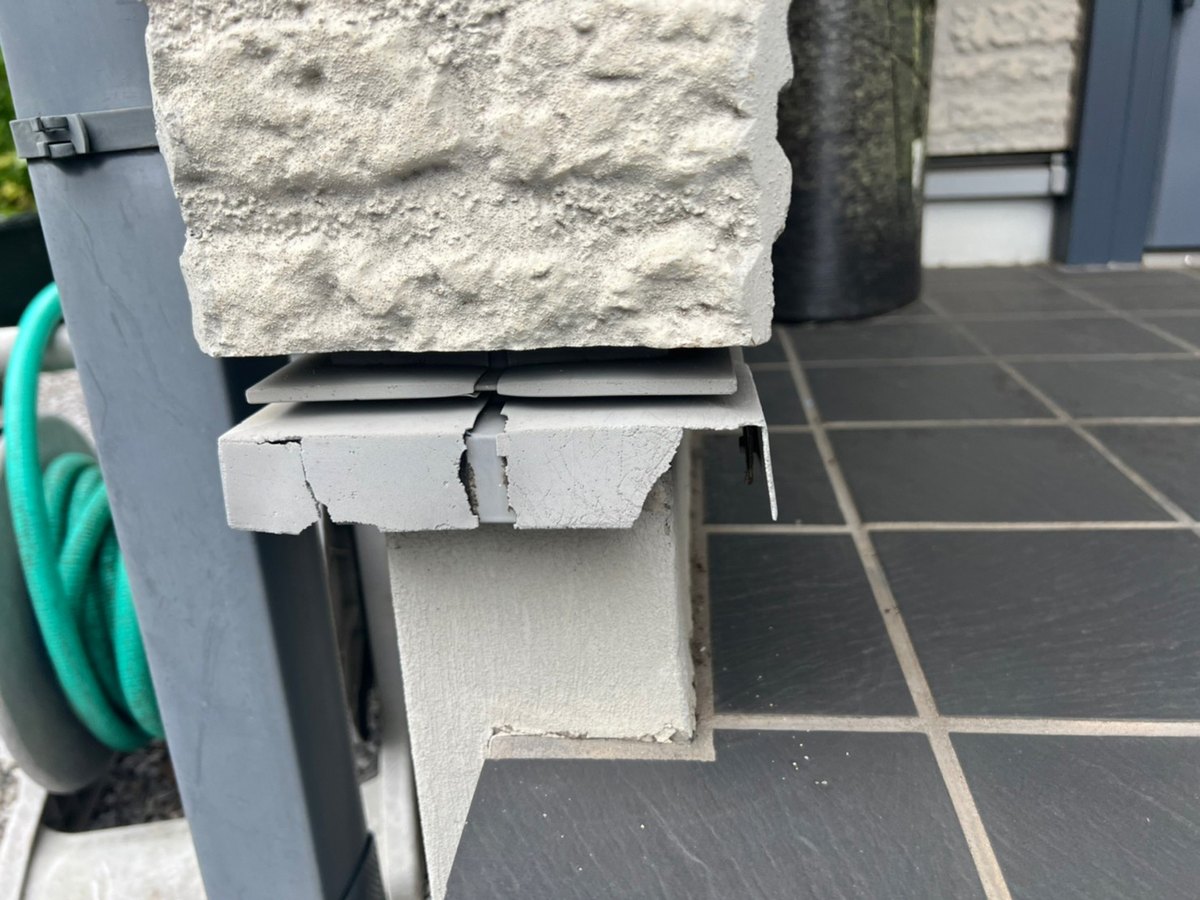 建物の足元の水切り板金の角で、割れていたジョイントの部材(施工前)