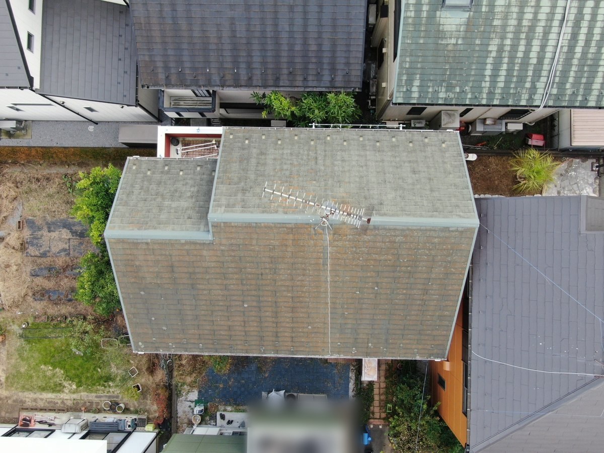 施工前の屋根（ドローンで真上から）。緑がかったグレーのスレートと古いアンテナ