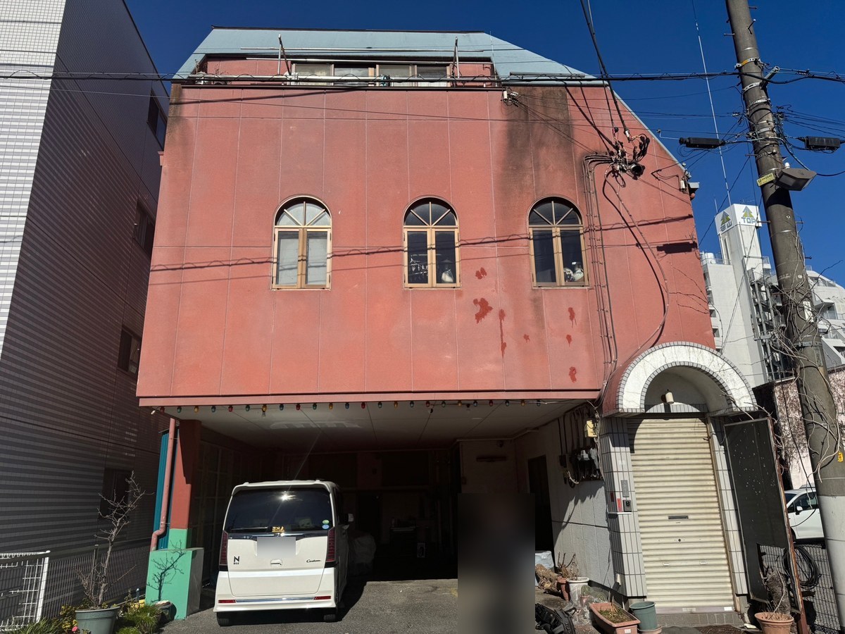 施工前の正面。赤みのある外壁に黒ずみの筋