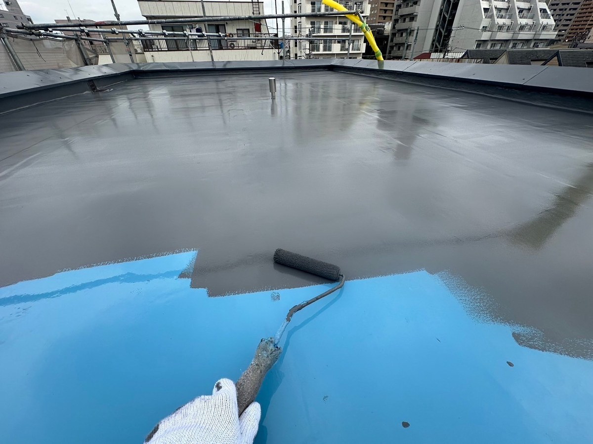 青い防水層の上にダークグレーのトップコート