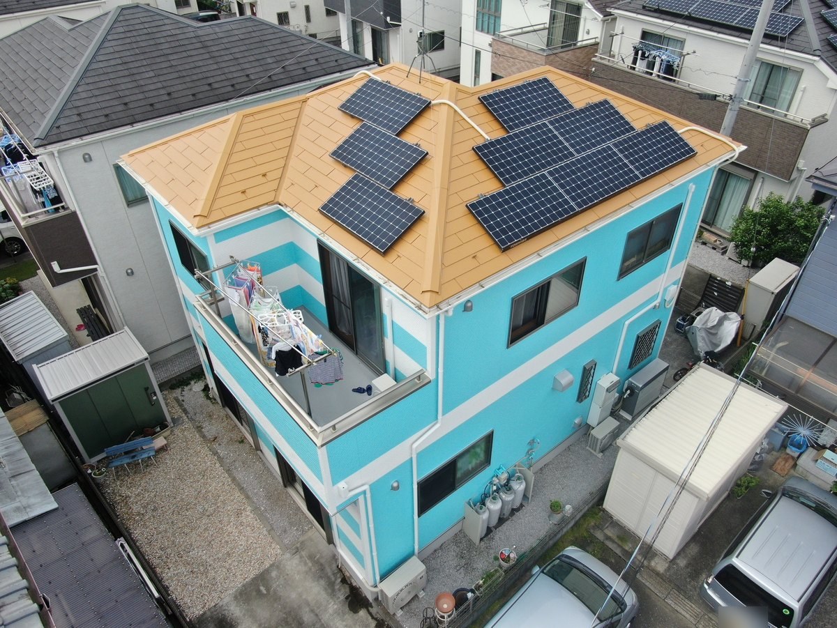 施工後の屋根と外壁（ドローン）。キャメルイエローの屋根と、付け直した太陽光パネル
