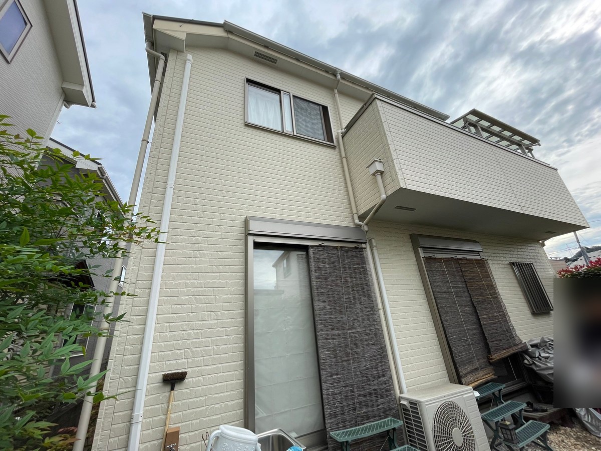 施工前の外観（バルコニー側）。クリーム色のレンガ調サイディング