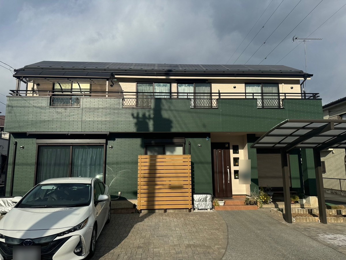 施工後の外観（正面）。1階を深い緑（45-30D）、2階をクリーム系（19-80C）に塗り替え