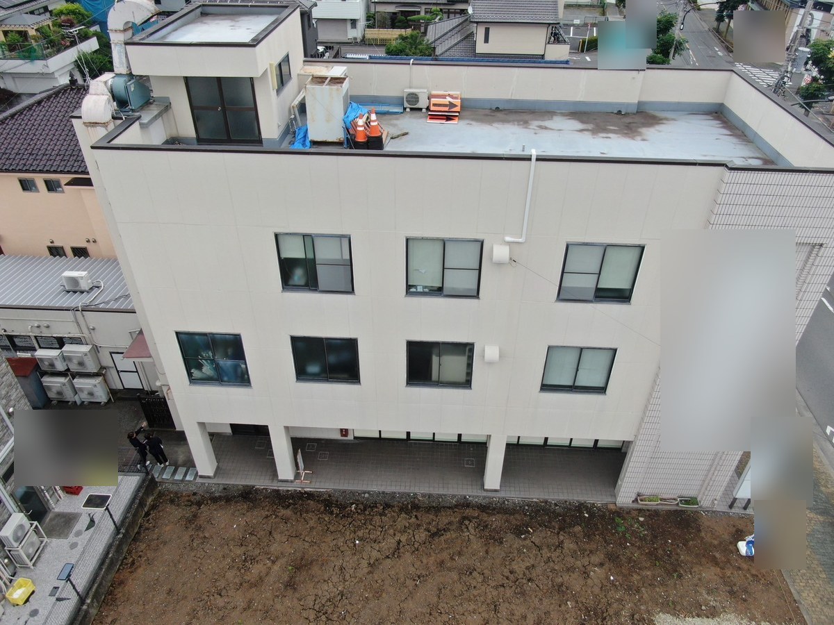 施工前の建物全体（上空から）。屋上の床に汚れと黒ずみ