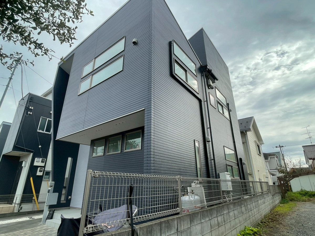施工後の外観（道路側の角から）。紺の外壁