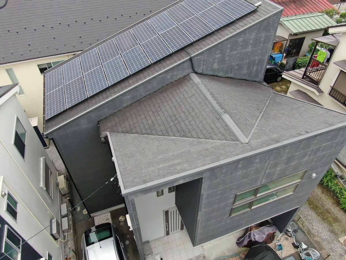 施工前の屋根（ドローン・斜め上から）。太陽光パネルと棟板金・ケラバ