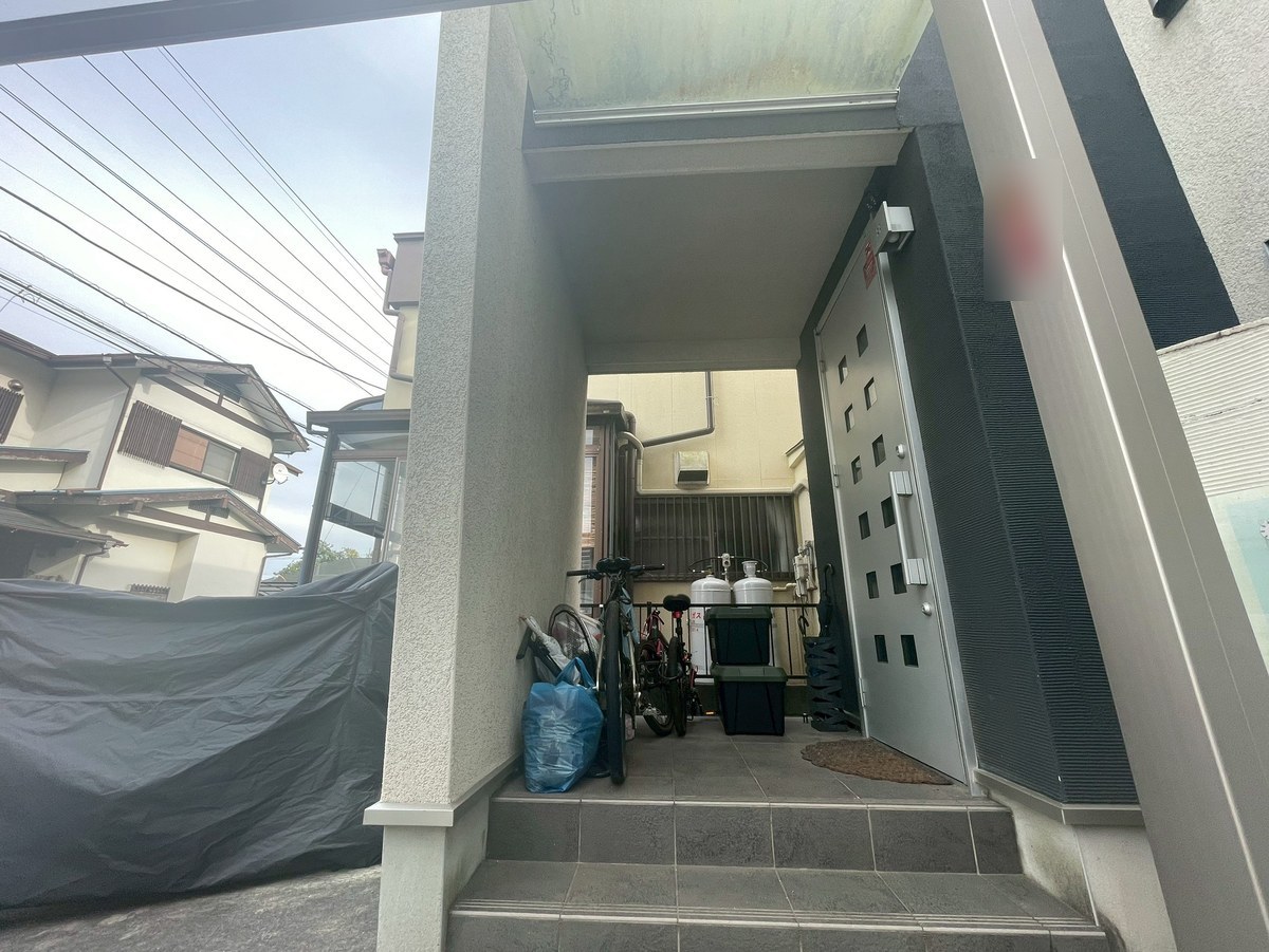 施工前の玄関まわり。左の面は明るい灰色、ドアの右の面は濃い灰色