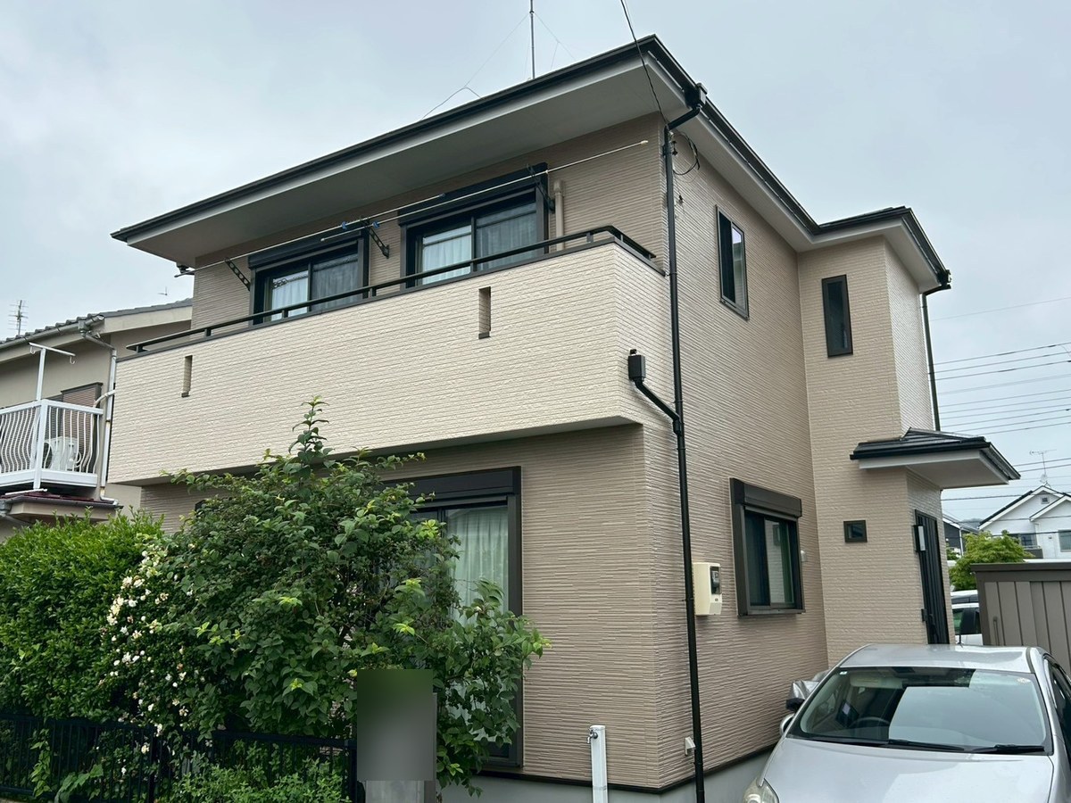 施工後の外観(玄関側)。壁はベージュ(19-60D)、腰壁と玄関まわりは明るい19-75D