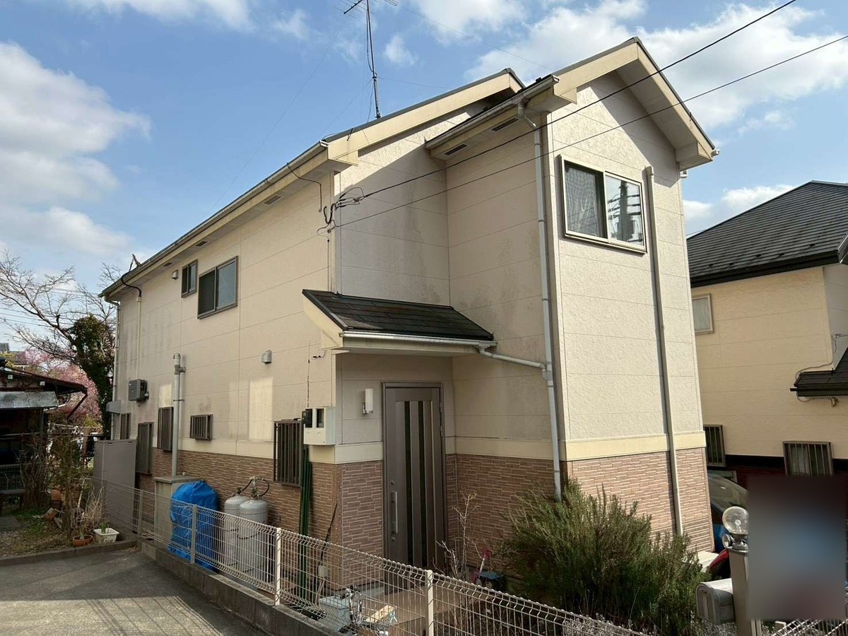 施工前の外観（玄関側）。2階はベージュの塗り壁調、1階は茶色のレンガ調